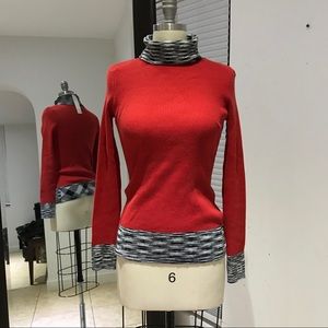 Bright red turtleneck with black and white details